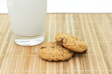 Cookies and a glass of milk on a bamboo table cloth