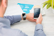 © REDPIXEL - Businessman uses smart watch and phone.