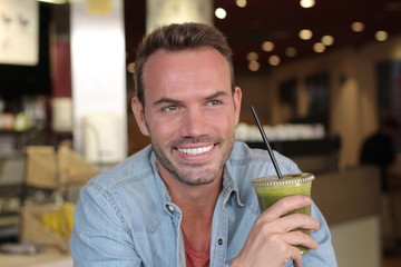 Handsome man drinking organic healthy smoothie for a perfect diet. Green food for a healthy life