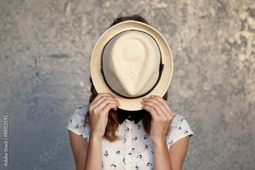 Fotografía Young girl with hat. Hides her face.Depression.