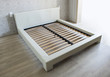 Bed in bedroom with wooden slats without mattress