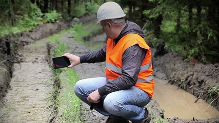 Sticker - Forest officer filmed with tablet PC rutted forest road
