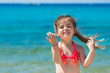 © Uncleraf - Happy smiling little girl on beach vacation, blu sea background