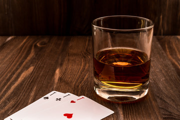 Wall Mural - Glass of whiskey and playing cards on the wooden table