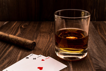 Wall Mural - Glass of whiskey and playing cards with cuban cigar on the wooden table