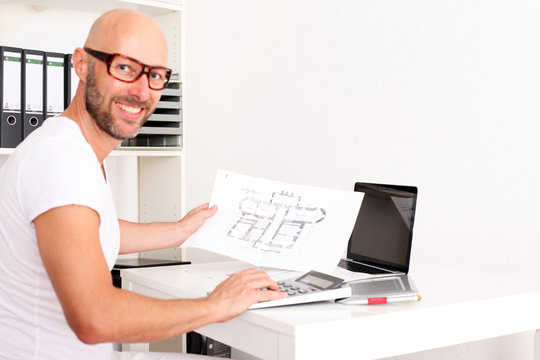 Architekt mit Bauplan und Notebook