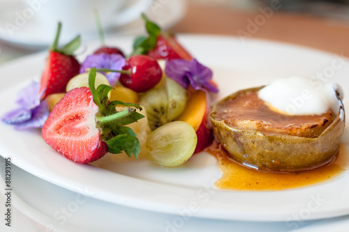 Fotografie, Obraz Warm, spicy baked apple with honey caramel sauce and bulgarian yoghurt, and fresh fruit decorated with edible purple flowers