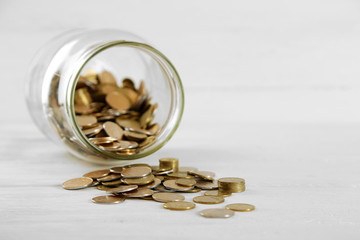 Wall Mural - Coins in money jar on wooden background