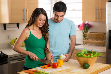 Beautiful woman and handsome man chopping vegetables organic salad paleo vegan vegetarian diet