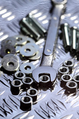 Nuts bolts washers spanner.
Various nuts bolts washers and a spanner on a steel background.