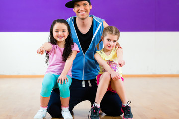  Dance teacher giving kids Zumba fitness class i