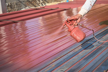Spray Red Color To Paint The Steel Of A Building