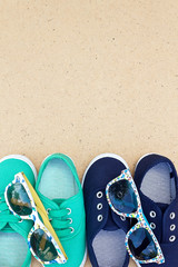 Green and blue sneakers and sunglasses on brown background