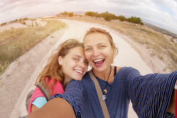 two women friends doing selfie, outdoors in the fields