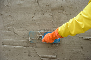 Builder worker plastering  concrete at wall