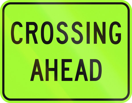 An Canadian warning traffic sign - Crossing ahead, green version. This sign is used in Ontario