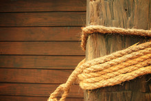 Rope Wrapped Around Wooden Post In Old Wooden Wall