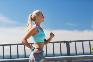 Wall Mural - smiling young woman running outdoors