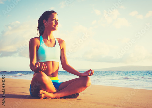 Fotografia Woman Practicing Yoga on the Beach at Sunset