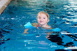 © cromary - Little child enjoying swimming pool. Cute toddler girl wearing colorful swimsuit and armbands having fun in the water. Adorable sportsman kid promoting healthy lifestyle.