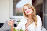 Fototapeta  - Sexy blonde woman eating salad outdoor