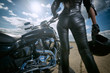 © Alex Shadrin - Biker girl in leather jacket standing by a motorcycle. Rear view