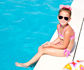 Cute smiling little girl in swimming pool