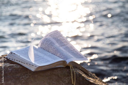 Fotografía La biblia en una piedra contra el mar