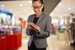 © patcharaporn1984 - Women in shopping mall using mobile phone.
