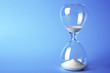 © Africa Studio - Hourglass on blue background