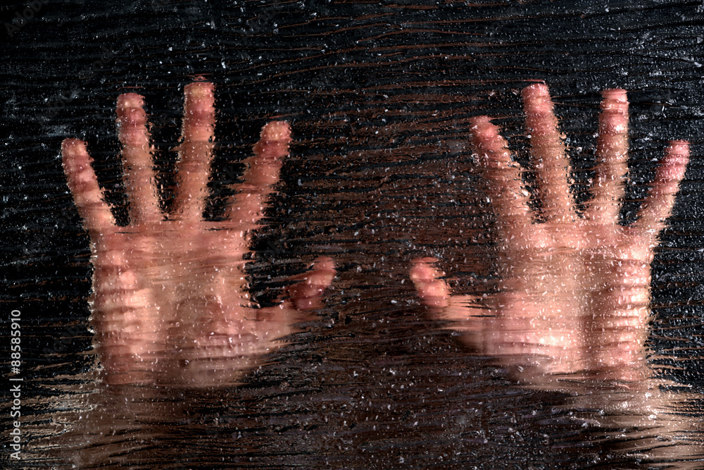 Male hands behind frosted glass, close-up
