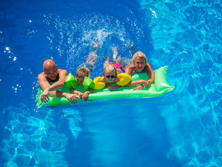 Family Outside Relaxing In Swimming Pool