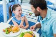 © WavebreakmediaMicro - Daughter and father eating at the restaurant
