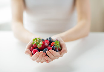 Wall Mural - close up of woman hands holding berries