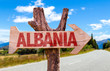 Albania wooden sign with road background