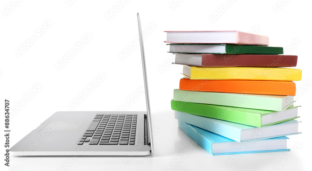 Stack of books with laptop isolated on white