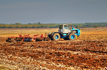 Farmer in tractor preparing land for sowing