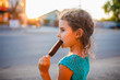 girl child eating ice cream outside a side view