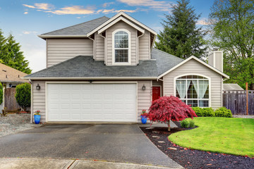 Modern home with red door and light grey exterior.