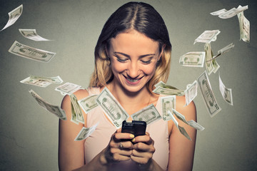 Happy woman using smartphone with dollar bills flying away from screen