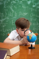 Wall Mural - concentrated boy examines globe