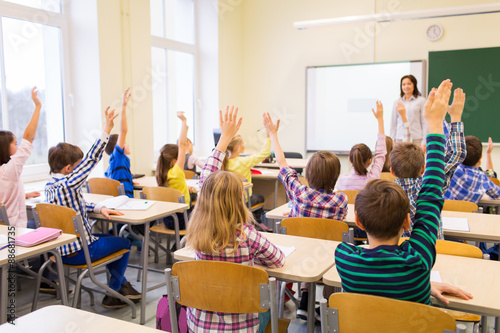 Cuadros en Lienzo group of school kids raising hands in classroom