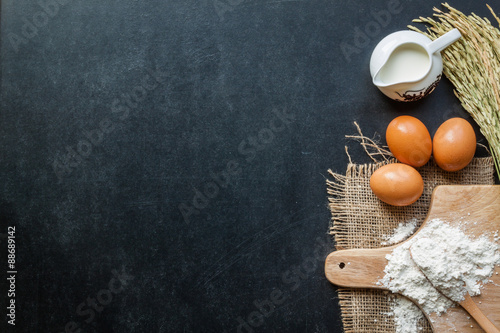 Fotografie, Obraz Baking powder milk and eggs on chalkboard for background