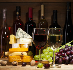 Wall Mural - Wine with various types of cheese on wooden background