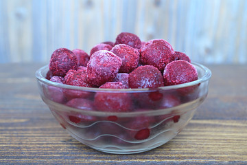 Wall Mural - Frozen cherries in a glass bowl on wooden  background