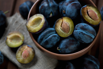 Wall Mural - Glass bowl full of ripe plums, close-up, high angle view