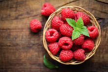 Fresh Ripe Red Raspberries In A Wicjer Bowl On Dark Rustic Wooden Background
