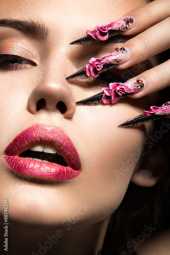 Foto Beautiful girl with long nails and sensual lips. Beauty face.