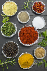 Wall Mural - Various spices in shiny bowls on a dark wooden table