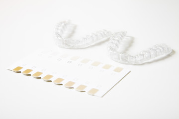 two dental whitening trays and a palette for tooth color